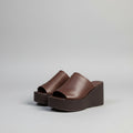 Pair of brown wedge sandals on a light gray background, Obroi