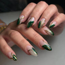 Close-up of a hand with green and gold nail art on a neutral background, Obroi