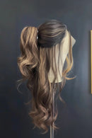 Mannequin head with long, wavy hair styled in a ponytail against a dark wall, Obroi