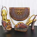 Pair of ornate high-heeled shoes with a matching handbag on a dark surface, Obroi