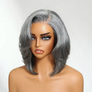 A shoulder-length gray wig with side-swept bangs and soft waves, displayed on a mannequin bust against a plain light background, Obroi