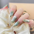 Close-up of a hand with decorative nails holding a white flower, Obroi