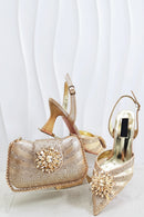 Gold embellished handbag and high-heeled shoes on a white background, Obroi
