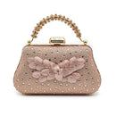 Rose gold handbag with floral design and beaded handle on a white background, Obroi