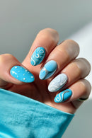 Hand with blue and white nail design against a neutral background ,Obroi