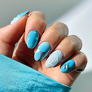 Hand with blue and white nail design against a neutral background ,Obroi