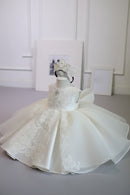 White lace dress on a mannequin with a tiara against a neutral background, Obroi