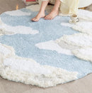 Round cloud-patterned rug on a floor with a person's feet visible, Obroi