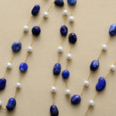Necklace with blue stones and pearls on a beige background, Obroi