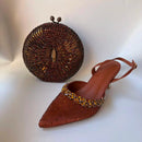 Brown beaded clutch and shoe on a white background, Obroi