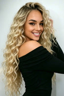 Woman with long, wavy blonde hair wearing a black off-shoulder top, Obroi
