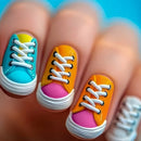 Colorful nail art design of sneakers on a person's fingernails with a blue background, Obroi