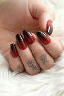 Close-up of a hand with red nail polish and floral tattoos on a soft white background, Obroi