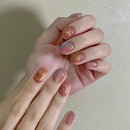 Hand with pink nail polish and floral designs on a plain background, Obroi