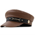 Brown leather cap with black band and gold accents on a white background, Obroi