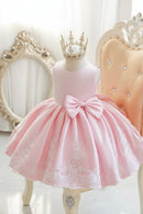 Pink dress with a large bow and lace details on a mannequin against an elegant background, Obroi