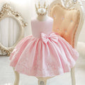 Pink dress with a large bow and lace details on a mannequin against an elegant background, Obroi