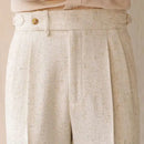 Close-up of beige textured pants with a button on a neutral background, Obroi