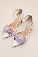 White high-heeled shoes with floral decorations on a beige background, Obroi