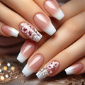 Close-up of hands with pink and white floral nail art on a decorative background, Obroi