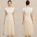 A woman modeling a sleeveless midi dress shown from the front and back against a light beige textured studio background. The dress has a white floral lace bodice with sheer mesh panels and a soft blush-beige tulle skirt, Obroi