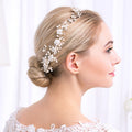 Obroi Woman wearing a decorative hairpiece with flowers and pearls on a white background