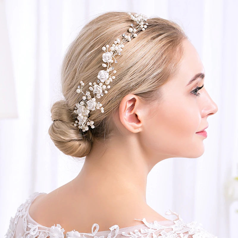 Obroi Woman wearing a decorative hairpiece with flowers and pearls on a white background