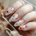 Nails with floral design held by a hand, Obroi