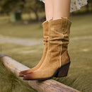 Brown suede boots on a wooden fence with a blurred natural background, Obroi