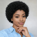 Woman with short, curly black hair wearing a light blue shirt against a plain background, Obroi
