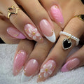 Close-up of hands with pink and white floral nail design on a white background, Obroi