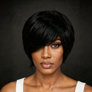A woman wearing a short, layered black wig with side-swept bangs, shown from the chest up against a dark gray studio background, Obroi