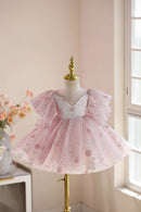 A pink tulle dress with a white sweetheart bodice and glittery floral embroidery, displayed on a mannequin in a softly lit indoor setting, Obroi