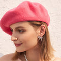 Woman wearing a pink beret with a white background, Obroi