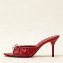 Red high-heeled shoe on a beige background, Obroi