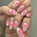 Obroi Close-up of a hand with pink floral nail art on a neutral background