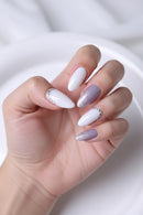Hand with white and purple nail polish on a white background, Obroi