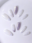 Set of decorative nails with white and purple designs on a white background, Obroi