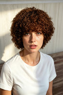 Woman with curly hair wearing a white shirt, shown from front, side, and back angles, Obroi
