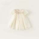 Cream-colored baby dress with ruffled sleeves on a white background, Obroi