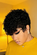 Woman with styled hair wearing a yellow sweater in a warm-toned room, Obroi