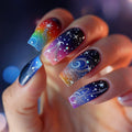 Nails with colorful galaxy design held by a hand against a blurred background, Obroi