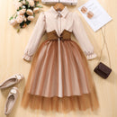 Two-tone dress with beige top and brown skirt on a wooden surface with shoes and flowers, Obroi