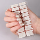 Hand holding a sheet of clear nail extensions against a neutral background, Obroi