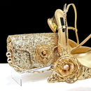 Gold clutch and high heels with floral embellishments on a white background, Obroi