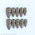 Set of ten brown and white patterned nails on a white background, Obroi