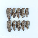 Set of ten brown and white patterned nails on a white background, Obroi