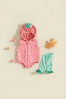A baby outfit set laid flat on a warm cream background, featuring a pink hooded romper with tiny dark polka dots and a mint green leaf detail on the hood, matching mint green and white striped tights, and a small orange crab toy, Obroi