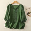 Green blouse on a hanger with a magazine in the background, Obroi