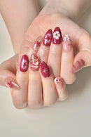 Close-up of hands with decorative nail art on a neutral background, Obroi